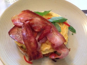 Golden folded scrambles with goats cheese, chilli + basil on grain toast