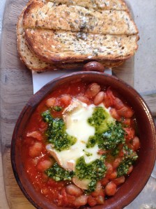 Home style baked borlotti beans with smoked ham hock and tomato ragout with gratinated Taleggio and basil pesto with toasted soldiers