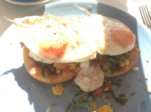 Huevos Rancheros - smoked and pulled beef brisket with Mexican fry bread, charred corn, tomato salsa, fried eggs, jalapeño sour cream & cilantro